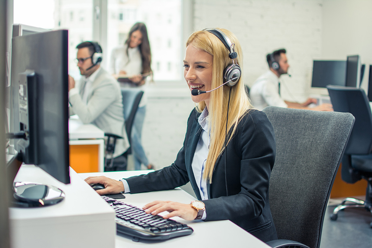 Commerciale équipée d un casque effectuant ses relances téléphoniques devant son écran